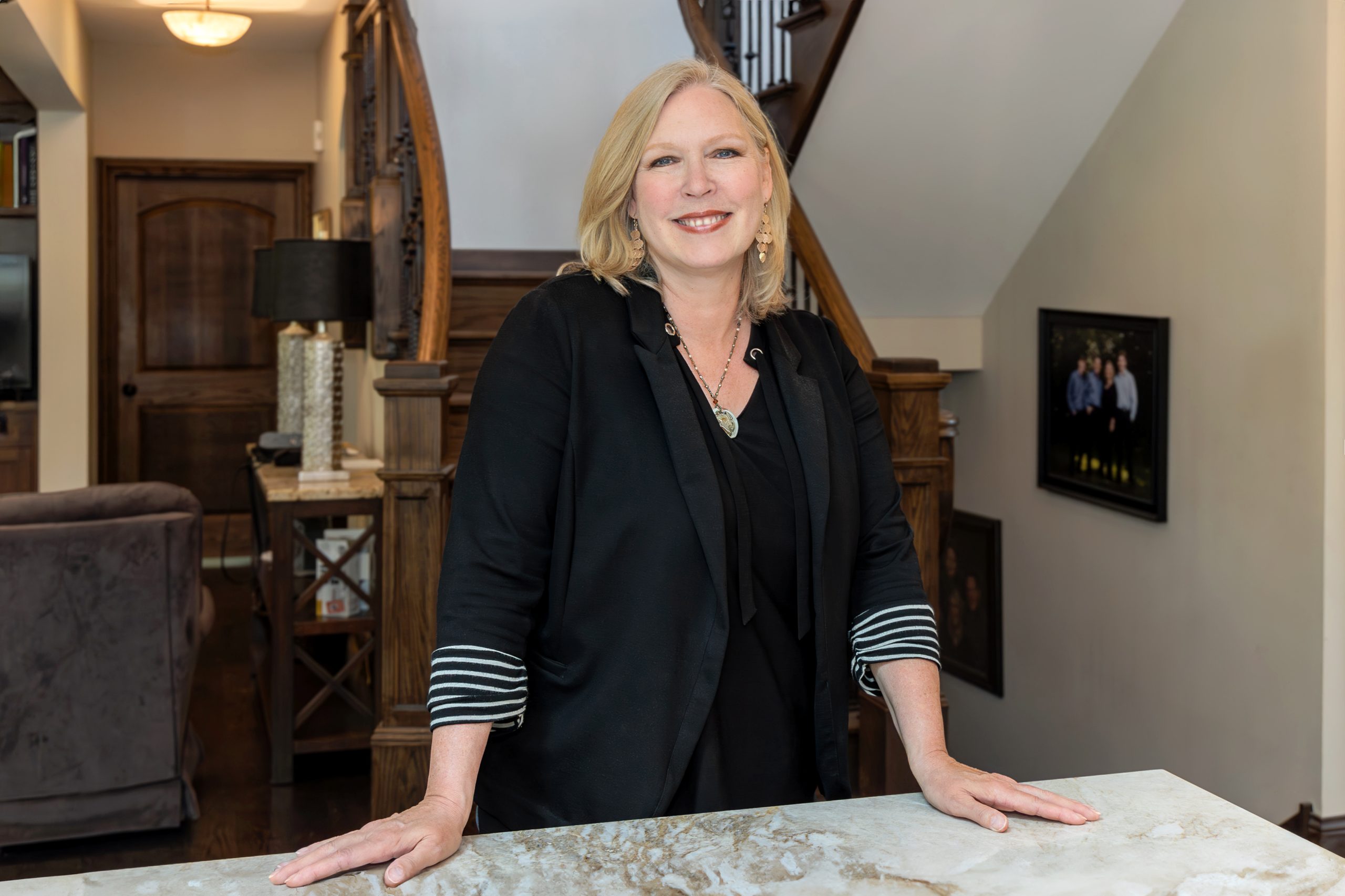 Shanon Tully of The Tully Team at Platinum Partners Realtors standing in a beautifully designed home interior, smiling confidently at the camera.
