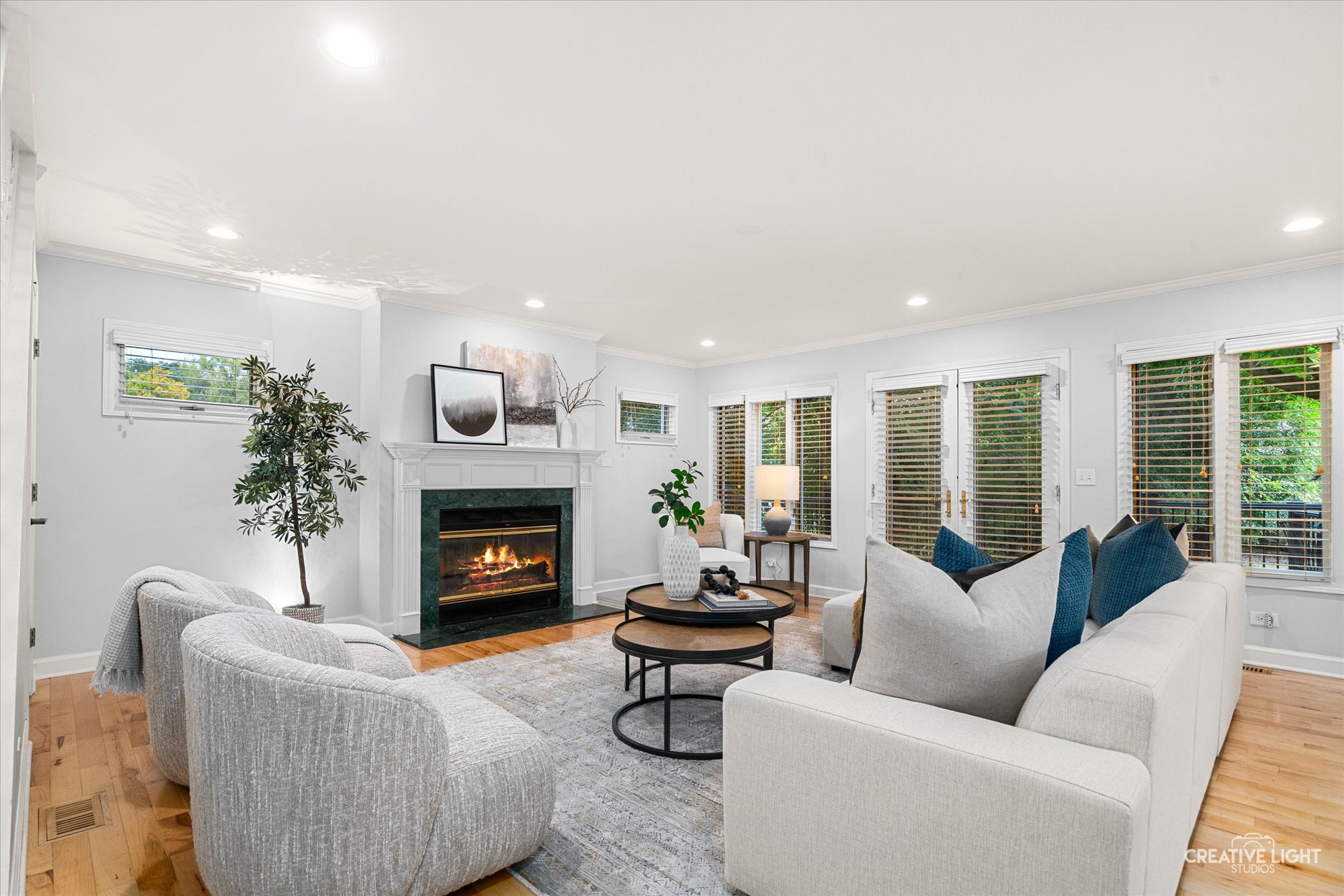 Family room at 1101 Barberry Court Downers Grove featuring gas fireplace, hardwood floors, neutral décor, and multiple windows overlooking the backyard.