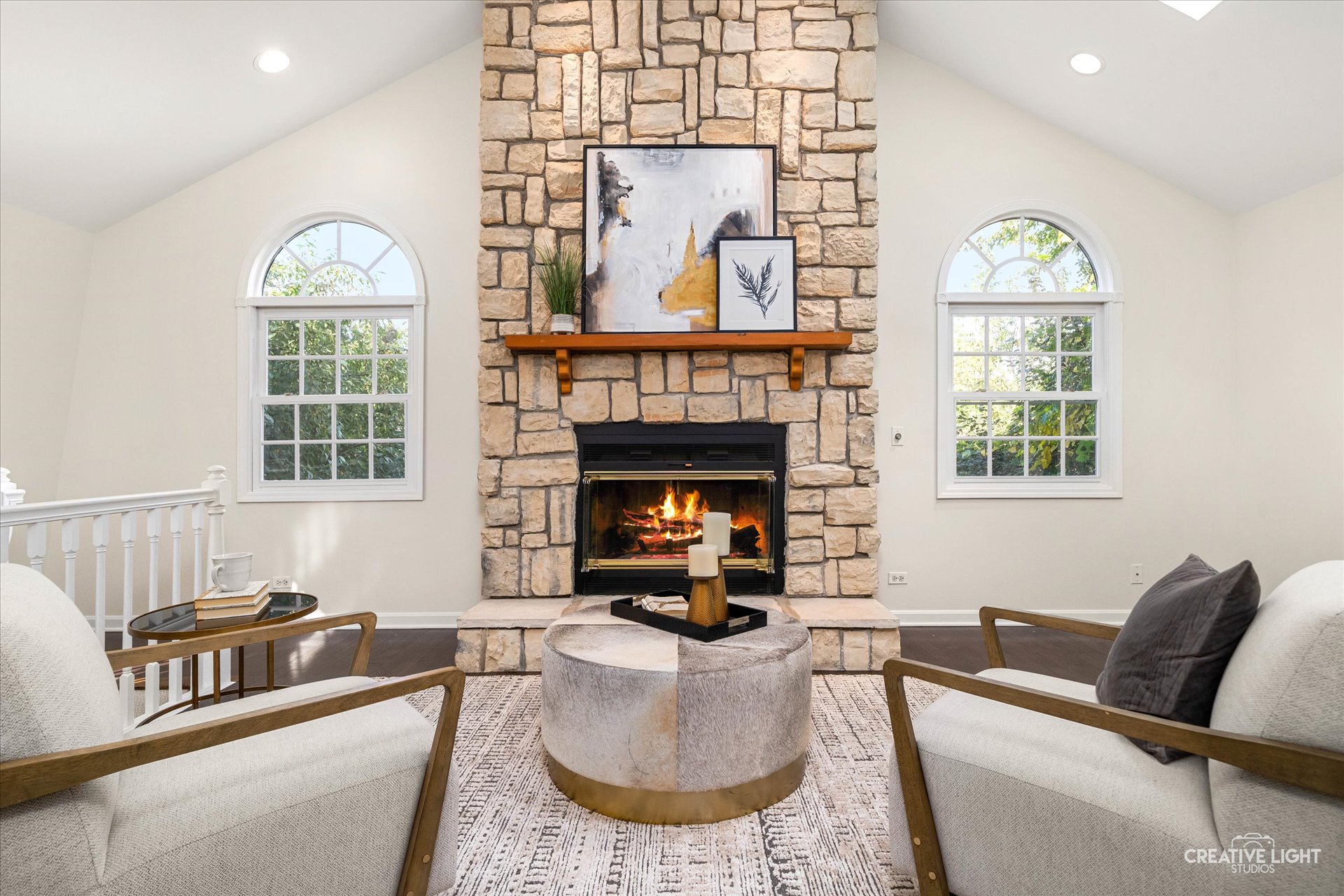 Upstairs sitting room at 1101 Barberry Court Downers Grove with vaulted ceiling, stone fireplace, and arched windows bringing in natural light.